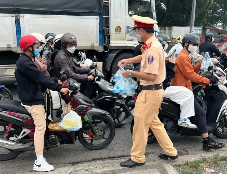 Cảnh sát giao thông phát nước, khăn lạnh cho người dân về quê đón Tết