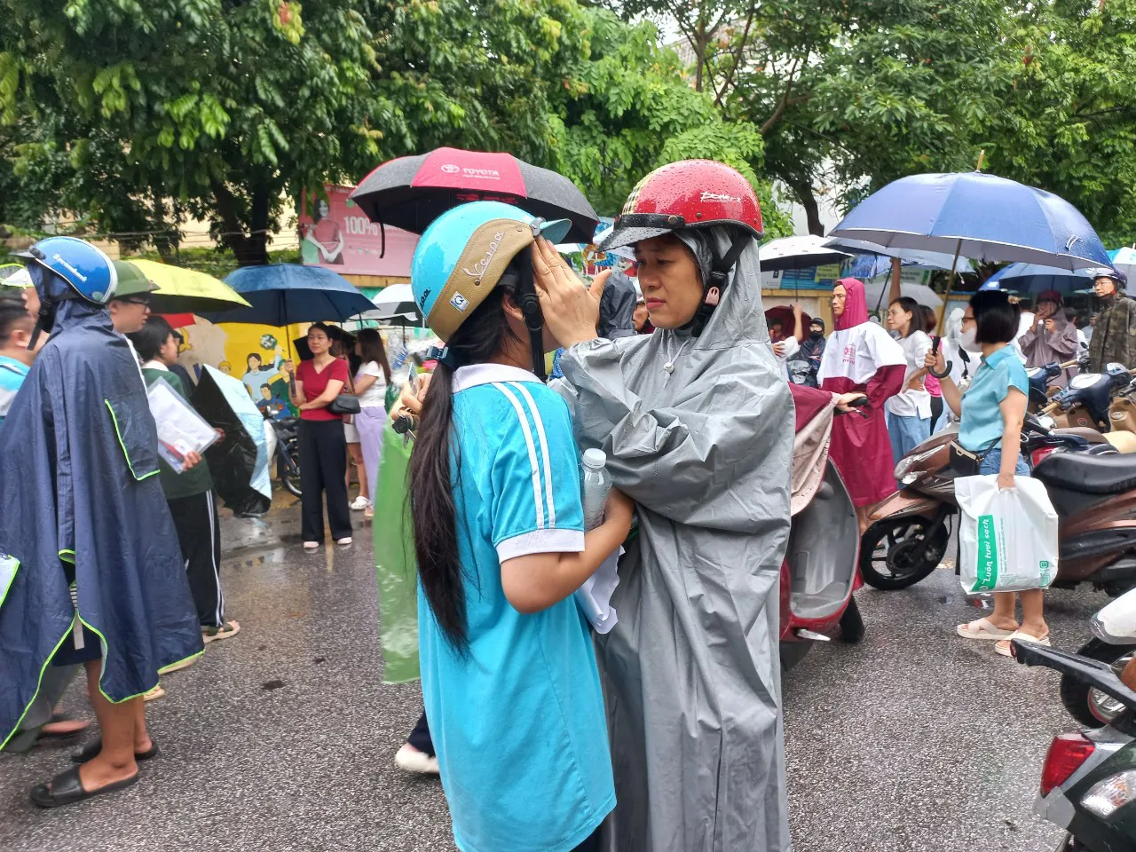 Mẹ động viên con tại điểm thi Trường THPT Phúc Lợi - quận Long Biên. Ảnh: Vi Giáng