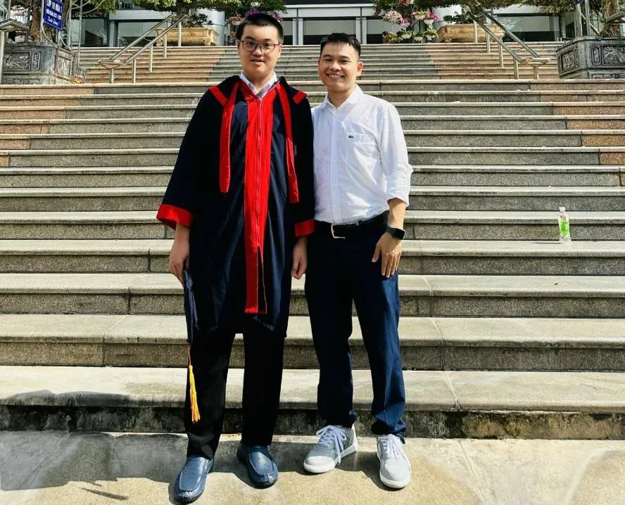 Minh Quân bên giáo viên chủ nhiệm - thầy Cao Văn Dũng.